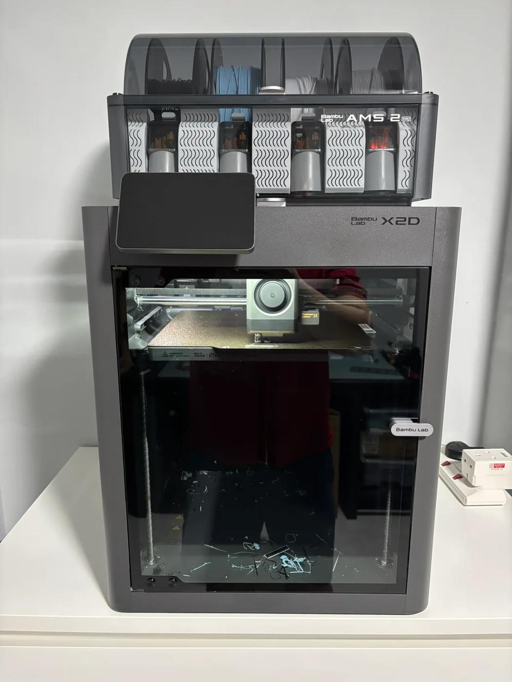 Bambu Lab X2D printer with an AMS filament unit above it.